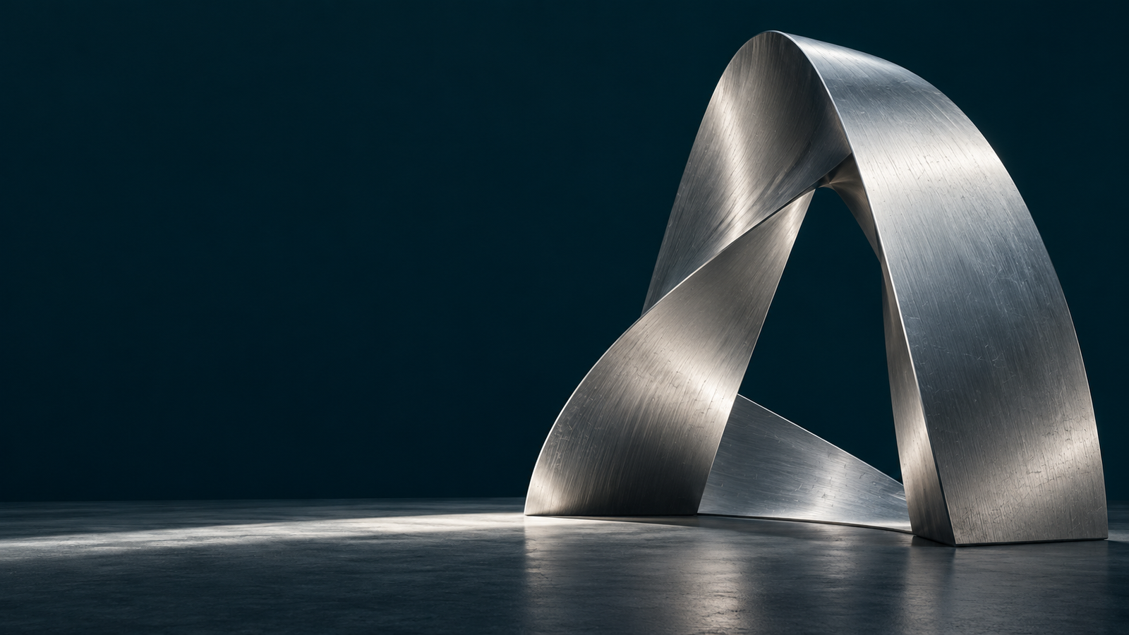 Sculptural silver loop in a dark architectural space